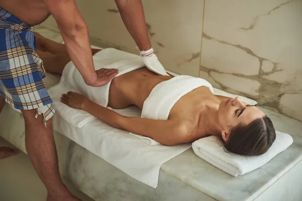 Carinhoso homem fazendo kese pilling para a senhora relaxada em hammam — Fotografia de Stock