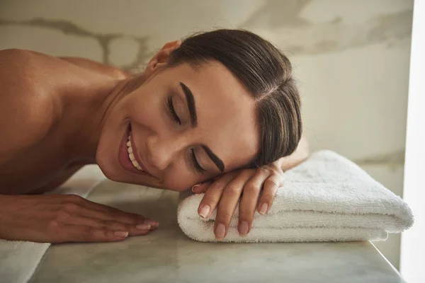 Portret van een vrolijke dame die glimlacht terwijl ze op de handdoek ligt — Stockfoto