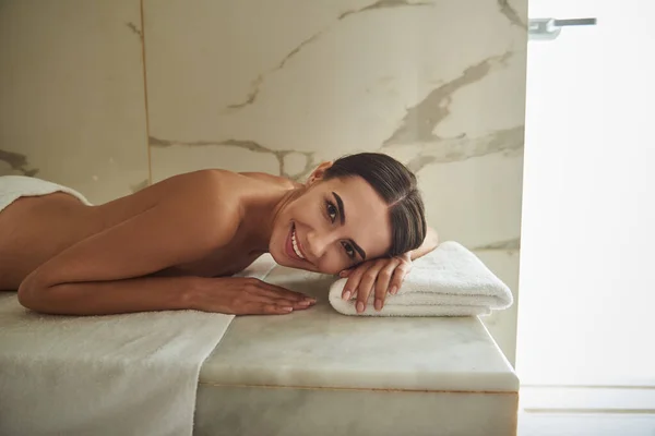 Feliz dama morena relajándose en el hammam y luciendo alegre — Foto de Stock