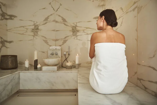 Спокойная леди в белом полотенце, сидя в турецкой бане — стоковое фото