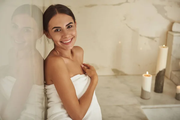 Šťastná dáma v ručníku s úsměvem při pohledu na vás — Stock fotografie