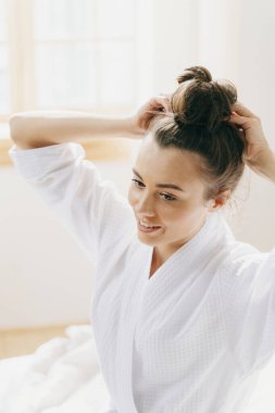 Güzel genç bir kadın kafasının arkasında el ele tutuşuyor.