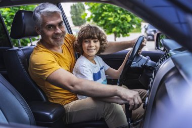 Mutlu beyaz çocuk ve babası kameraya poz veriyor.