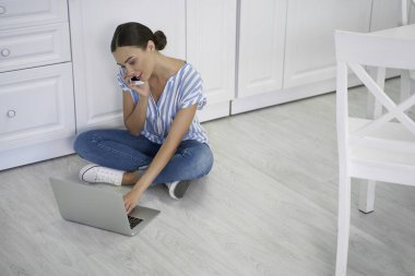 Bilgisayarlı ve akıllı telefonlu gülümseyen bayan.