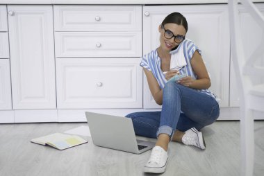 Telefondaki gülümseyen kadın ve çalışan kadın.