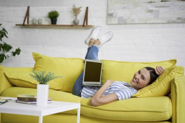 Kanepede dizüstü bilgisayarı olan mutlu bir serbest yazar.