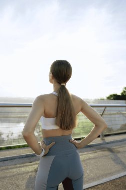 Atletik genç bayan açık havada antrenman yapıyor.