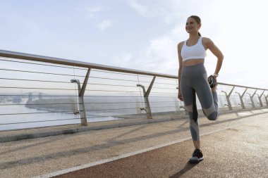 Dışarıda antrenman yapan neşeli atletik bayan.