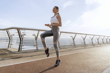 Mutlu kadın köprüde koşuyor.