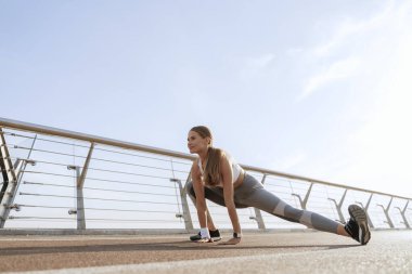 Mutlu bayan yan bacakları esnetiyor.