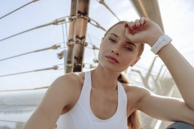 Köprüde oturan sportif yorgun bayan.