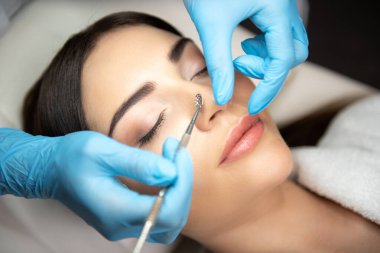 Kozmetik uzmanı, siyah başlıklı temizlikçi kadın.