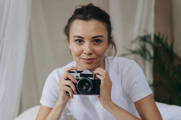 Hübsche junge Frau hält Kamera zu Hause — Stockfoto
