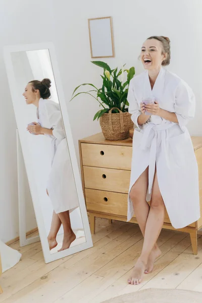 Mujer bastante joven se ríe en el dormitorio —  Fotos de Stock