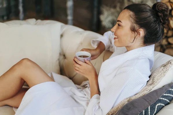 Feliz joven dama está sosteniendo taza de bebida caliente — Foto de Stock