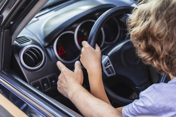 Caucasian man teaching little boy how to drive vehicle — ストック写真