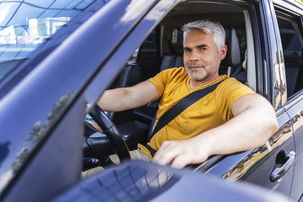 Uśmiechnięty biały mężczyzna prowadzi samochód. — Zdjęcie stockowe