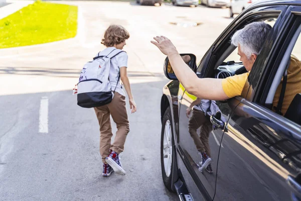 Mature homme caucasien voyant petit garçon hors de l'école — Photo