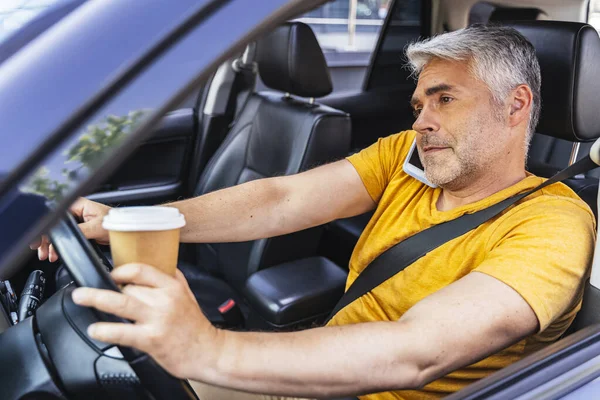Geschäftiger Kaukasier mit Cupholder im Arm fährt sein Auto — Stockfoto