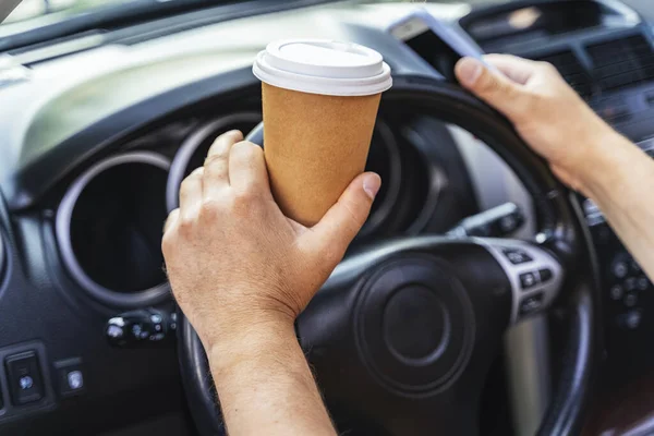 Mężczyzna prowadzi samochód i pije kawę. — Zdjęcie stockowe