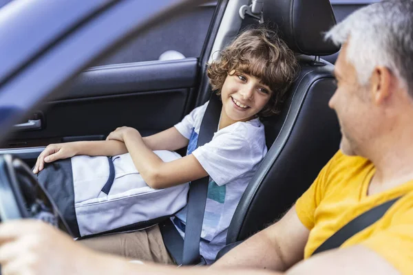 Маленький мальчик смотрит на своего взрослого отца в машине — стоковое фото
