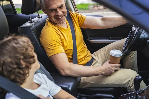 Petit garçon assis près de son père mature dans la voiture — Photo