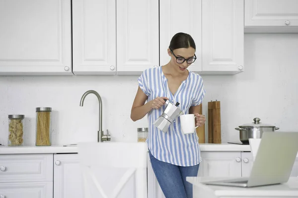 Усміхнена дама наливає гарячу каву на кухню фото — стокове фото