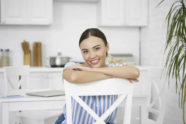 Beautiful smiling woman sitting on the chair stock photo — Stock Photo, Image