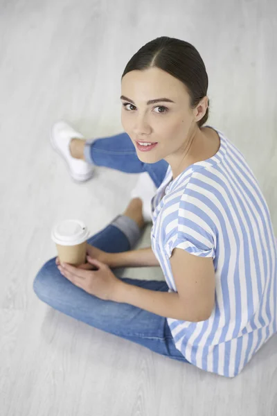 Mujer joven en el suelo con café foto de stock — Foto de Stock