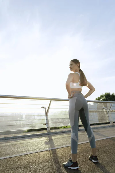 Spor yapan genç bir bayan açık havada antrenman yapıyor.