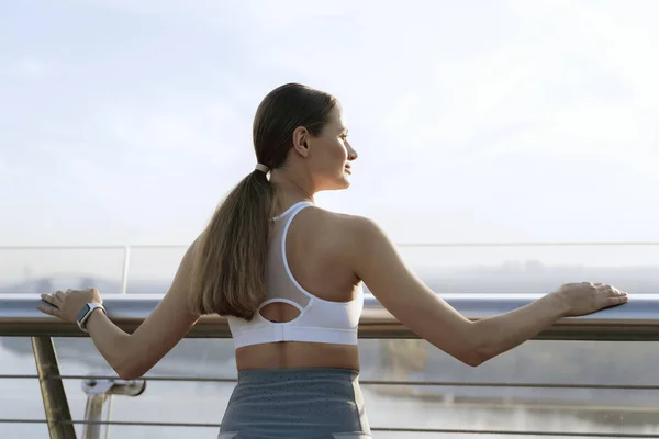 Felice signora sportiva incontrare alba sul ponte a piedi — Foto Stock