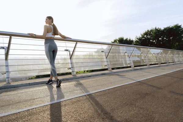 Senhora esportiva que fica no deck de observação da ponte — Fotografia de Stock