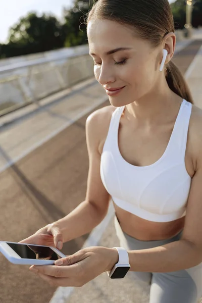 Heureuse femme athlétique dans les écouteurs avec mobile — Photo