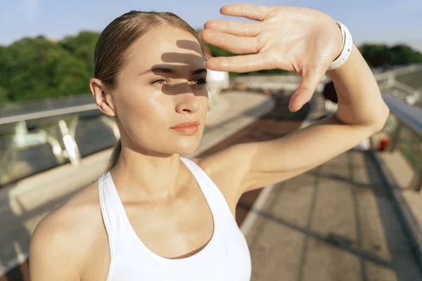 Senhora calma esportiva que se esconde do sol à mão — Fotografia de Stock