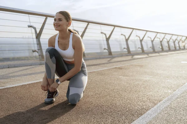 Gülümseyen atletik kadın spor ayakkabısı bağcıkları