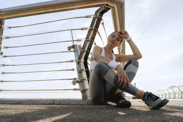 Sportovní dáma odpočívající na mostě zem — Stock fotografie