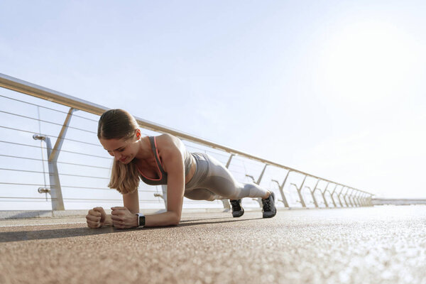 Young athletic lady staying in plank position