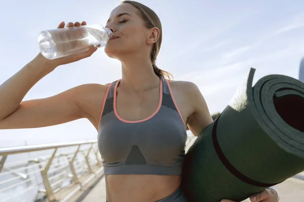 Спортивна дама п'є чисту воду після тренування — стокове фото