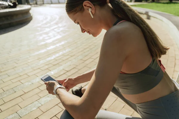 Joven mujer deportiva escuchar música por teléfono —  Fotos de Stock