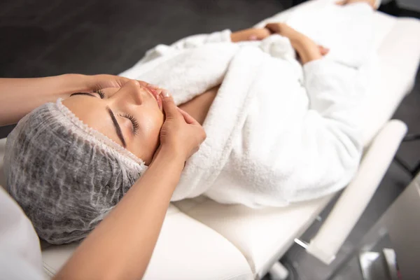 Profesionální masérka masérka masáž obličeje v lázeňském salonu — Stock fotografie