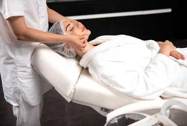 Massagem massagista profissional rosto de senhora encantadora no salão de spa — Fotografia de Stock