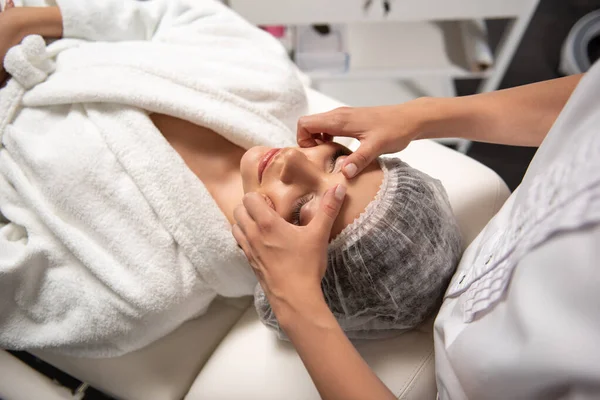 Mujer joven recibiendo masaje facial en el salón de spa — Foto de Stock