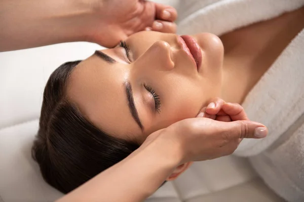 Vacker ung kvinna som får ansiktslyftning massage — Stockfoto