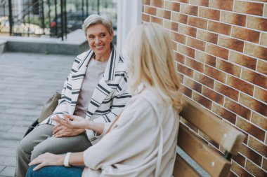 Memnun yaşlı bayan arkadaşıyla oturuyor.