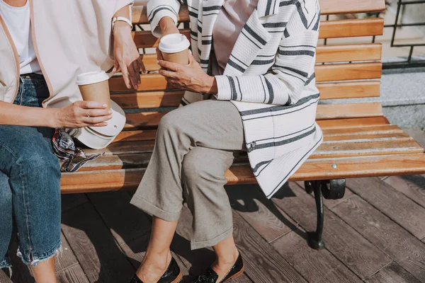 Две женщины держат бумажные чашки кофе — стоковое фото