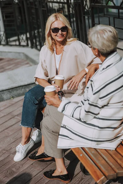 Lächelnde Frau mit einer Tasse Kaffee aus Papier — Stockfoto