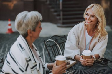 Masada oturan zarif kadınlar.