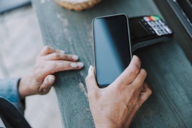 Akıllı telefonlu beyaz bir kadının elleri.