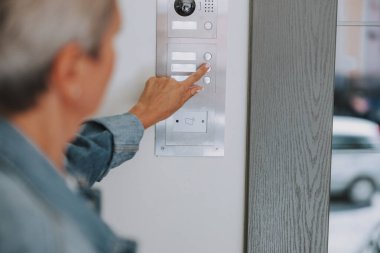 Bir dişinin eli zili çalıyor.