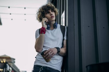 Delikanlı dışarıda telefonla konuşuyor.